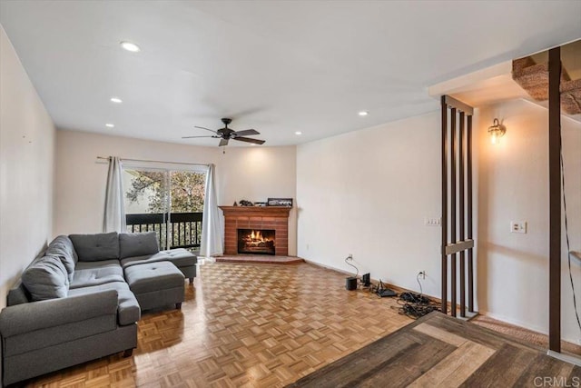 living room with parquet floors, ceiling fan, and a brick fireplace