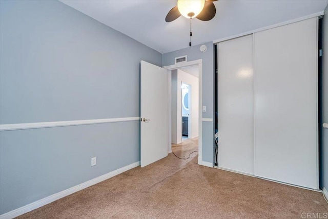 unfurnished bedroom with a closet, ceiling fan, and carpet flooring