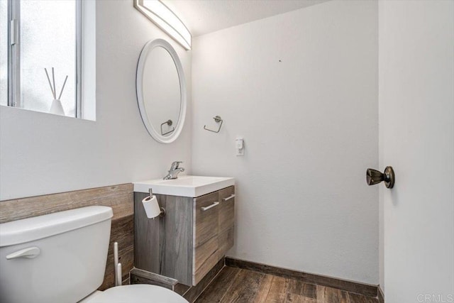 bathroom with hardwood / wood-style flooring, vanity, and toilet