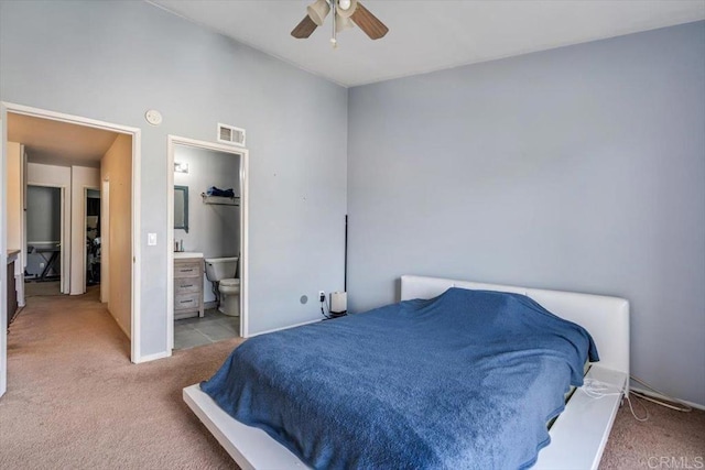 carpeted bedroom featuring ceiling fan and ensuite bath