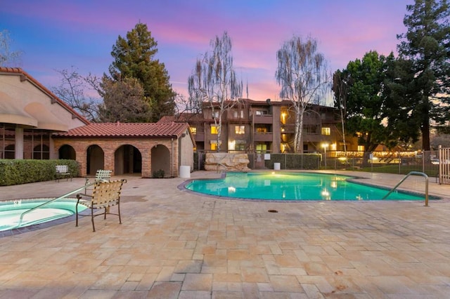 pool at dusk featuring a patio area