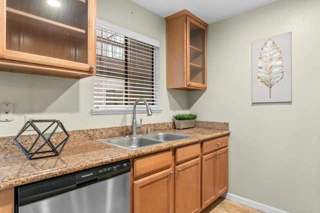 kitchen featuring sink, stainless steel dishwasher, and light stone counters