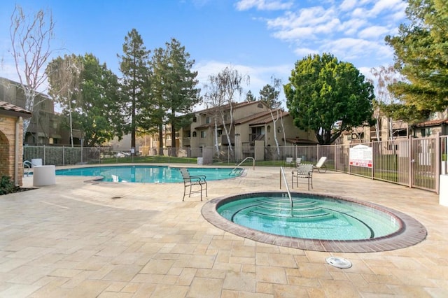 view of pool with a hot tub and a patio