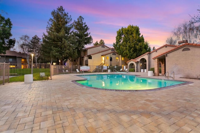 pool at dusk with a patio