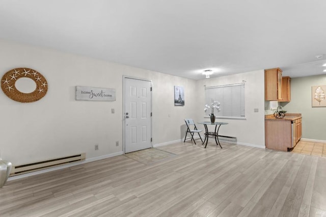 interior space with a baseboard heating unit and light hardwood / wood-style flooring