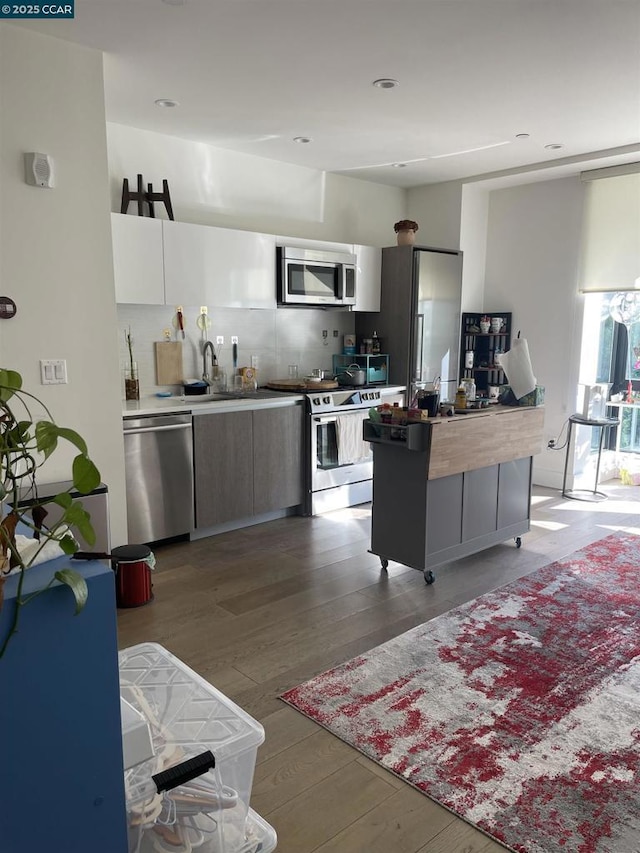 kitchen featuring sink, light hardwood / wood-style flooring, appliances with stainless steel finishes, a kitchen island, and white cabinets