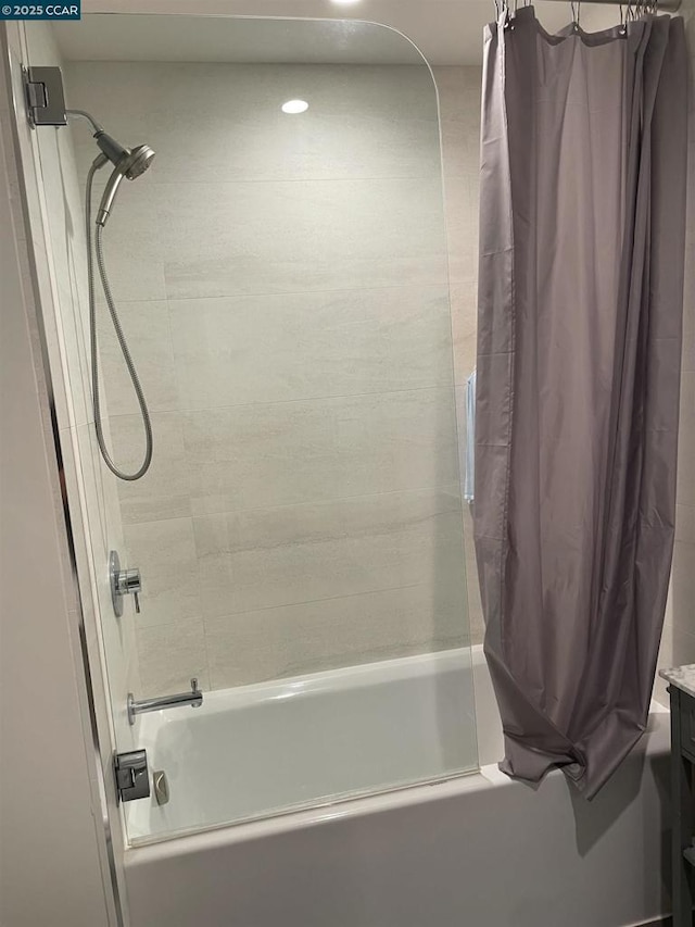 bathroom featuring vanity and shower / bathtub combination with curtain