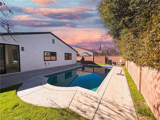 pool at dusk with a patio