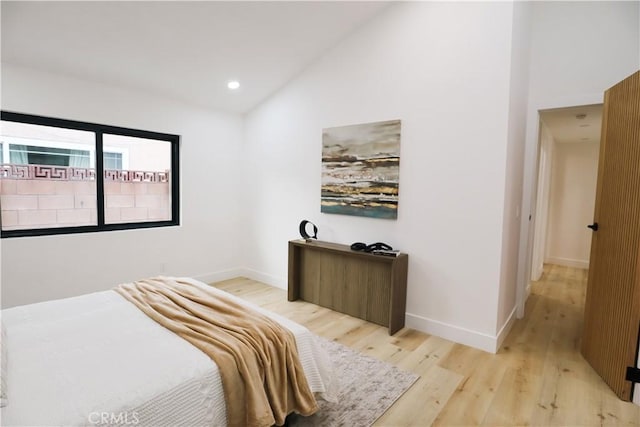 bedroom featuring vaulted ceiling and light hardwood / wood-style floors