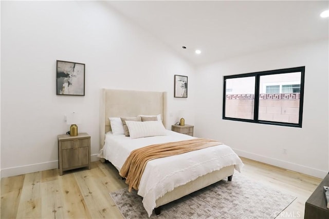 bedroom featuring vaulted ceiling and light wood-type flooring