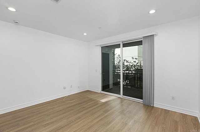 unfurnished room with recessed lighting, baseboards, and wood finished floors