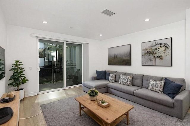 living room featuring baseboards, recessed lighting, visible vents, and wood finished floors