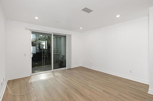 empty room featuring baseboards, recessed lighting, visible vents, and wood finished floors
