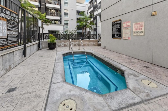 view of swimming pool featuring fence