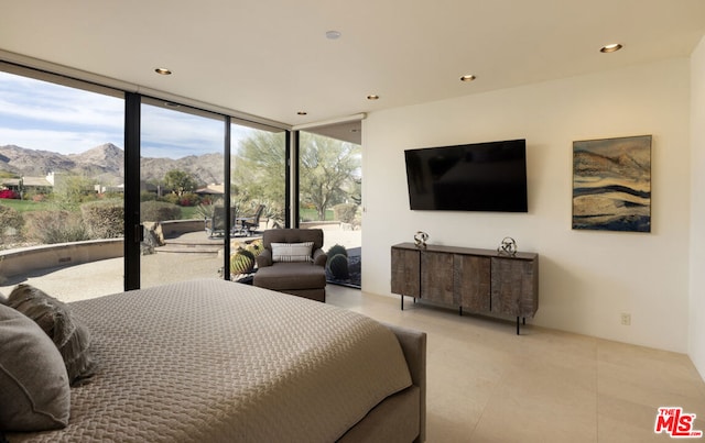 bedroom with expansive windows, access to exterior, a mountain view, and light tile patterned floors