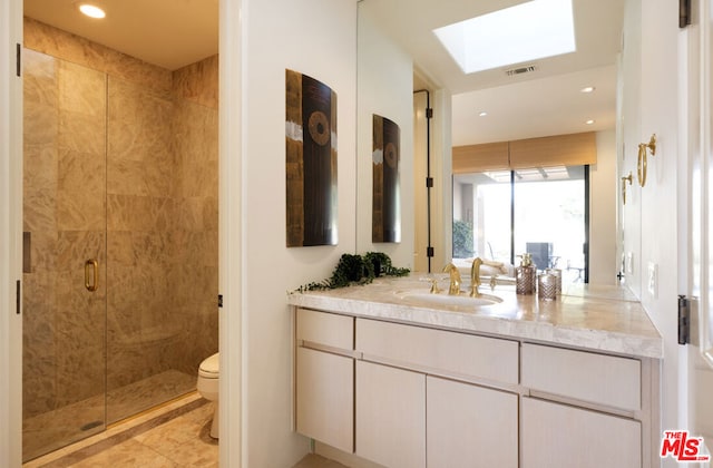 bathroom featuring vanity, an enclosed shower, a skylight, and toilet