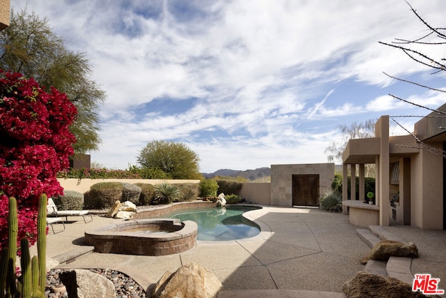 view of swimming pool with an in ground hot tub and a patio