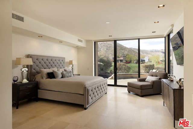 bedroom featuring access to outside and a wall of windows