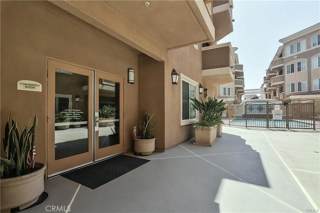 property entrance featuring a community pool and a patio