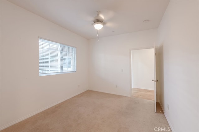 empty room featuring light colored carpet and ceiling fan