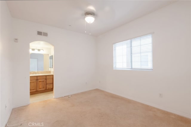 unfurnished bedroom with light carpet, sink, and ensuite bath