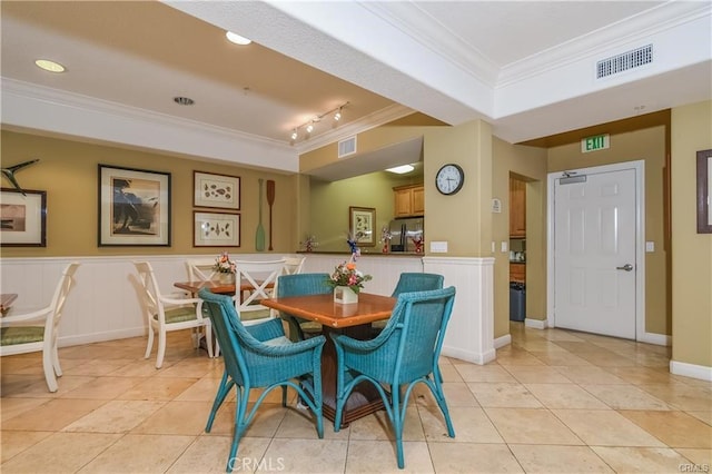 tiled dining area with track lighting and ornamental molding