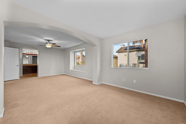 empty room featuring light colored carpet and ceiling fan