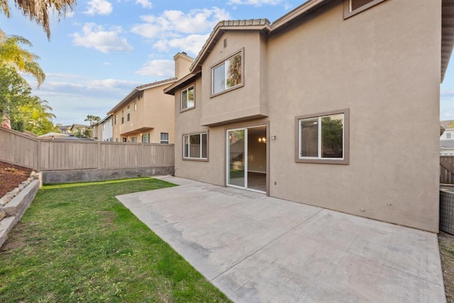 back of house featuring a patio area and a lawn