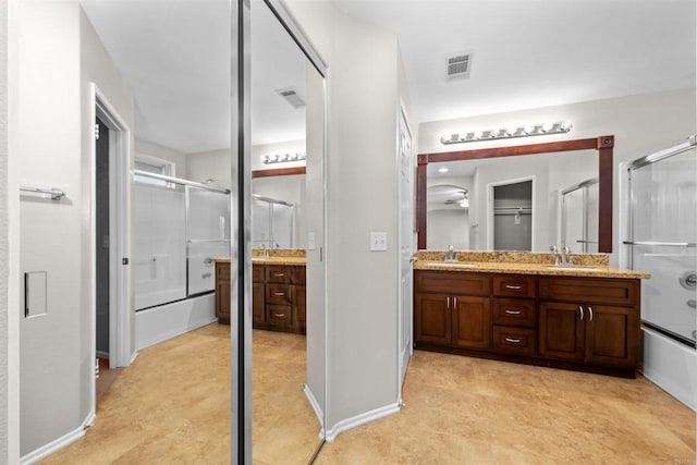 bathroom featuring vanity and combined bath / shower with glass door