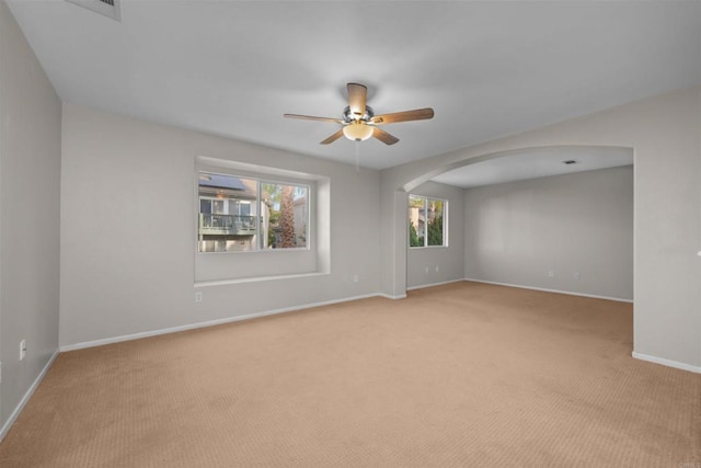 spare room featuring light carpet and ceiling fan