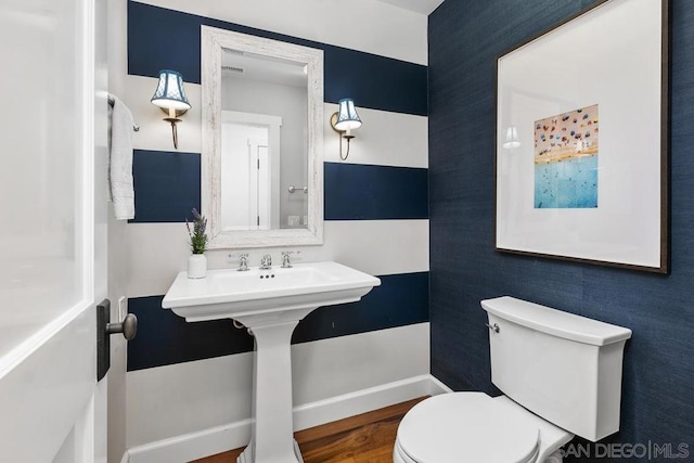 bathroom with hardwood / wood-style flooring and toilet