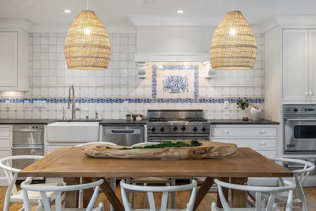 kitchen featuring white cabinetry, stainless steel appliances, sink, and tasteful backsplash