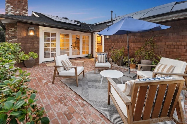 patio terrace at dusk with an outdoor living space and french doors