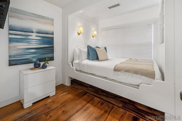 bedroom with dark hardwood / wood-style flooring