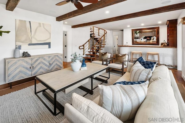 living room featuring beamed ceiling, hardwood / wood-style flooring, and ceiling fan