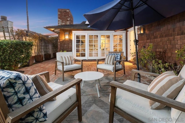 patio terrace at dusk with french doors and an outdoor hangout area