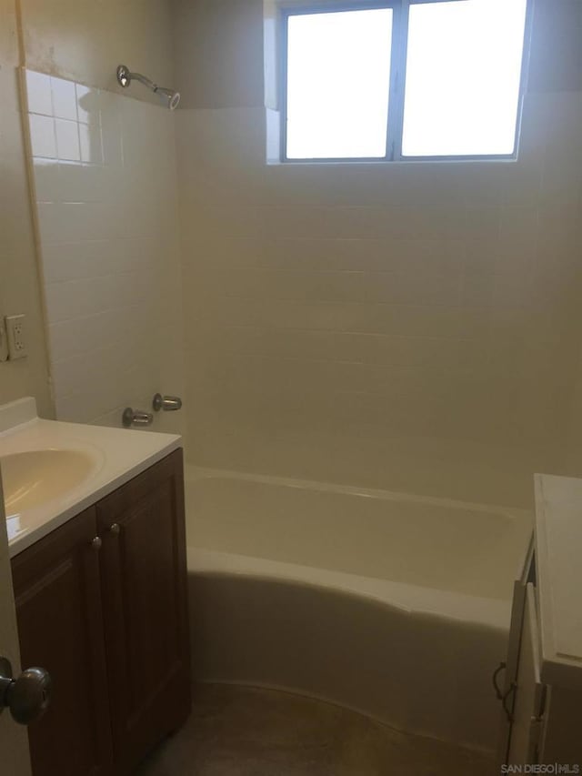 bathroom with tiled shower / bath and vanity