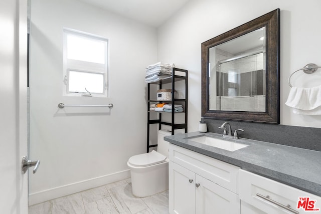 bathroom featuring vanity, toilet, and walk in shower