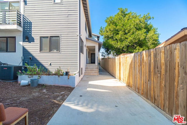 view of property exterior with central AC and a patio area