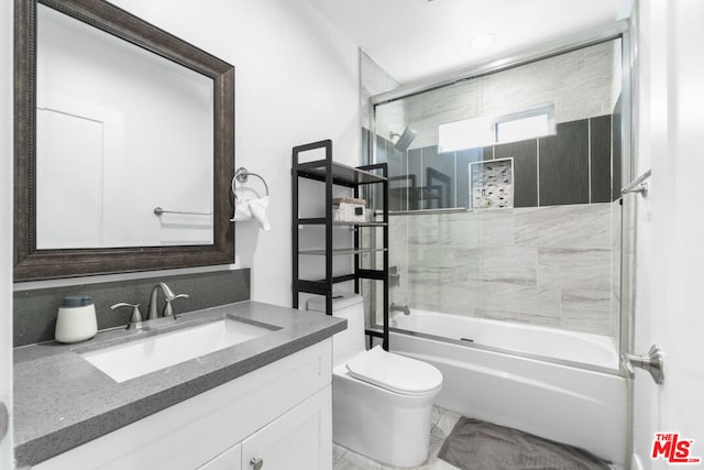 full bathroom with vanity, bath / shower combo with glass door, and toilet