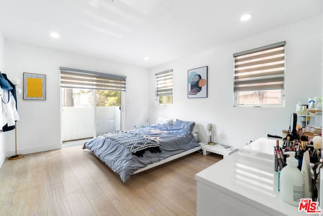 bedroom with access to outside and light wood-type flooring