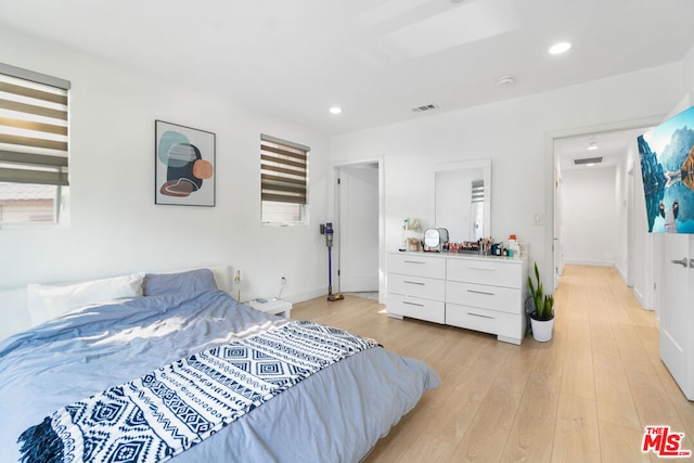 bedroom featuring multiple windows and light hardwood / wood-style flooring