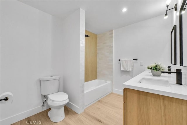 full bathroom with vanity, hardwood / wood-style flooring, tiled shower / bath combo, and toilet