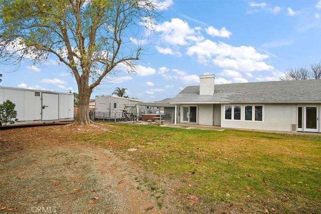 back of property with a patio area and a lawn