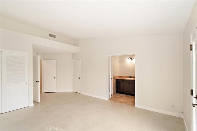 unfurnished bedroom with sink, ensuite bath, and a closet