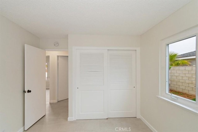 unfurnished bedroom with a textured ceiling and a closet