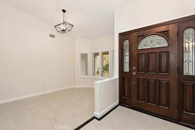 foyer with a chandelier and light tile patterned flooring