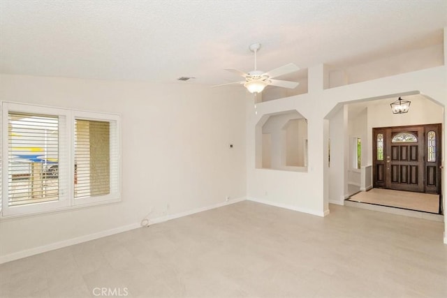 interior space featuring lofted ceiling, a textured ceiling, and ceiling fan