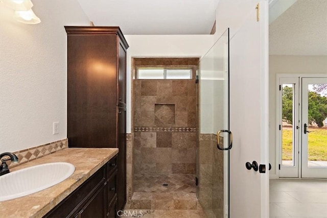 bathroom with walk in shower, vanity, and a wealth of natural light