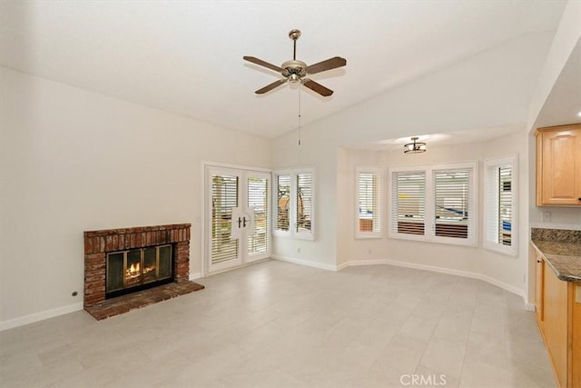 unfurnished living room with a fireplace, vaulted ceiling, french doors, and ceiling fan